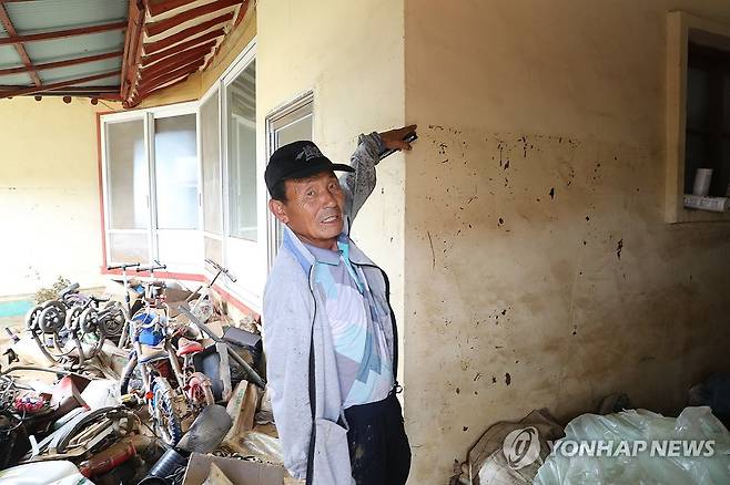 "성인 키보다 높다" (예산=연합뉴스) 한종구 기자 = 18일 오전 충남 예산군 삽교읍 하포리 폭우 피해 현장에서 한 주민이 성인 키만큼 물이 차올랐음을 설명하고 있다. 2025.7.18. jkhan@yna.co.kr