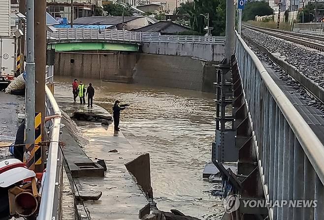 폭우에 휩쓸린 실종자 수색 (광주=연합뉴스) 18일 광주 북구 신안교에서 경찰과 소방대원들이 실종자를 수색하고 있다. 전날 광주에는 하루 426.4㎜의 폭우가 쏟아지면서 60대 남성으로 추정되는 인물이 신안교 부근에서 실종됐다. 2025.7.18 [광주소방본부 제공. 재판매 및 DB 금지] in@yna.co.kr
