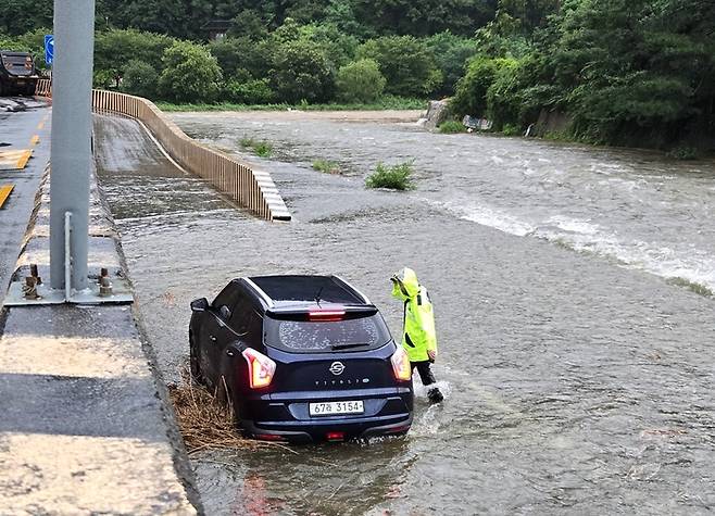 집중호우로 침수된 가창댐 하류 노상 주차장에서 가창파출소 경찰관이 고립된 차량 주변을 수색하고 있다.<가창파출소 제공>
