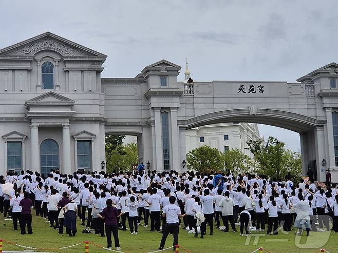 김건희 특검팀이 18일 건진법사 청탁 의혹 관련 경기 가평군 설악면 소재 통일교 본부를 압수수색한 가운데 신도들이 본부 입구에서 예배를 하고 있다. 2025.7.18/뉴스1 ⓒ News1 양희문 기자