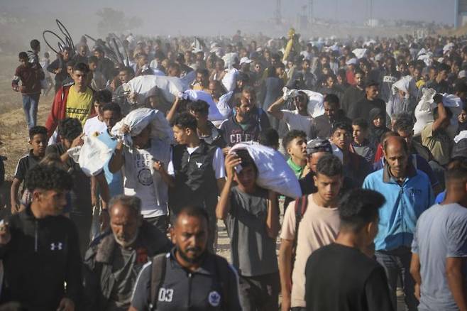 팔레스타인 가자지구 남부 라파로 들어온 피란민들이 가자 인도주의 재단(GHF)이 배급한 식량을 받고 있다. AP연합뉴스