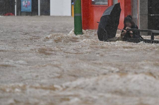 광주 지역에 폭우가 쏟아진 17일 오후 침수된 광주 북구청 앞 도로에서 한 시민이 물살에 휩쓸리고 있다. 뉴시스