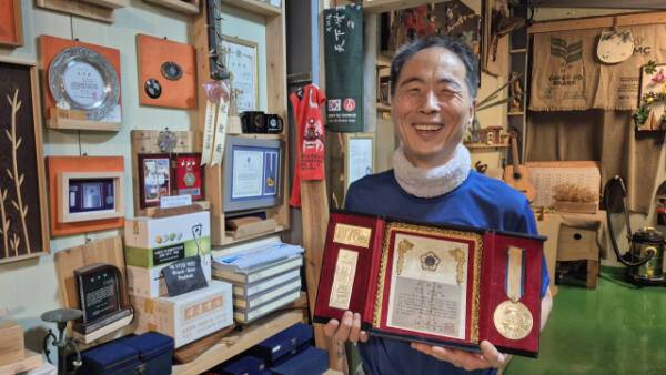 ‘부흥국수’ 2대 권완구 사장(63)이 1대 창시자이자 스승인 고(故) 이길훈씨가 1978년 받은 표창패를 들어 보이며 미소 짓고 있다. 금유진기자