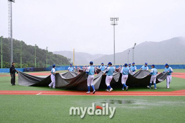 비가 내려 방수포를 설치하는 선수들. /횡성베이스볼테마파크=유진형 기자