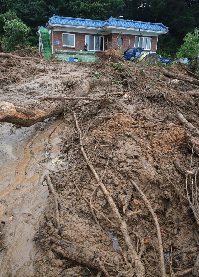 18일 전날 내린 폭우로 산사태가 발생한 충남 예산군 봉산면의 한 마을에서 토사와 나무가 주택과 축사를 덮쳐 처참한 모습을 보이고 있다. 주민은 "자고 있는데 쾅 소리가 들려 놀라 급히 나와보니 순식간에 흙이 쏟아졌다"라면서 "조금만 늦었다면 고립됐을 것"이라고 밝혔다. 예산=오승현 기자
