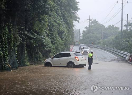 ◇전국 곳곳에 밤새 폭우가 내린 20일 강원 춘천시 서면 오월리 한 도로 물웅덩이에 SUV 차량이 빠져 있다. 2025.7.20 사진=연합뉴스