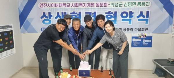 왼쪽부터 김용배 추진위원, 김진득 새마을지도자, 김성진 용봉리 이장, 김상대 영진사이버대학교 사회복지계열 동문회장, 이동식 동문회 수석부회장, 최형임 교수(사회복지학과·입시처장)가 협약 체결을 기념해 케이크 커팅을 하고 있다. 의성군 마을자치지원센터