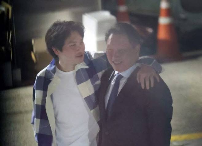 최태원 SK그룹 회장(오른쪽)이 지난해 6월 서울 강남구 한 식당 앞에서 장남인 최인근 씨와 어깨동무를 하며 대화하고 있다.(사진=온라인 커뮤니티 캡처)