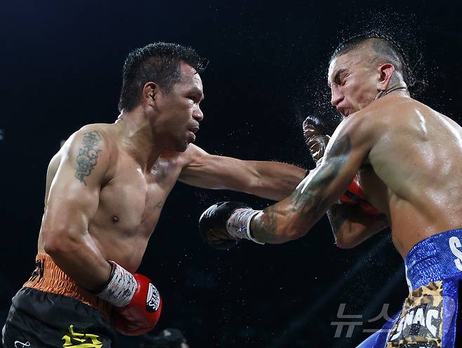 파키아오(왼쪽)가 20일(한국시간) 미국 네바다주 라스베이거스의 MGM그랜드가든아레나에서 열린 WBC 웰터급 타이틀전에서 챔피언 바리오스와 경기하고 있다. ⓒ AFP=뉴스1