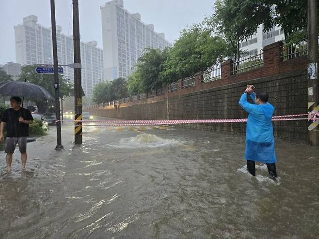 안형주 서구의원이 지난 17일 금호동 한 어린이보호구역이 빗물에 침수되자 도로를 지나는 차량들을 우회 시키는 등 피해 예방을 최선을 다했다. 독자제공