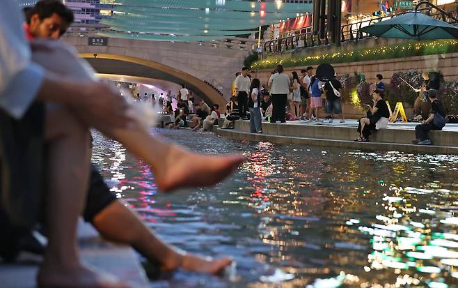 이른 폭염과 함께 열흘 넘게 열대야가 이어지고 있는 지난 9일 저녁 서울 중구 청계천을 찾은 시민들이 더위를 식히고 있다. /뉴스1