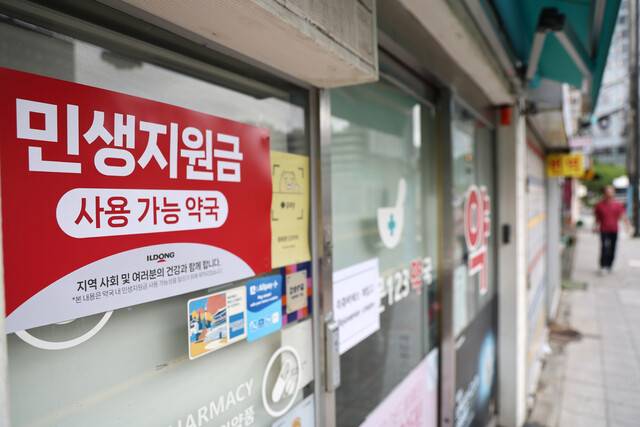 민생회복 소비쿠폰 1차 신청·지급을 하루 앞둔 20일 서울의 한 약국에 사용 관련 안내문이 부착돼 있다. 연합뉴스