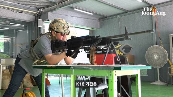 기자가 K16 기관총을 쏘고 있다. 왼쪽에 탄피가 날아가는 장면이 찍혔다. 화면 캡처