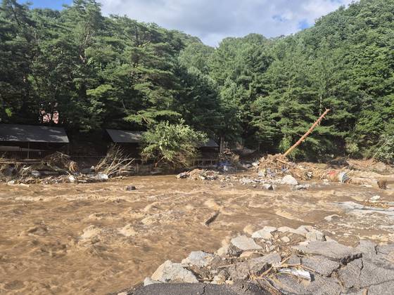 20일 산사태로 일가족 3명이 실종된 경기도 가평군 조종면 마일리 한 글램핑장 앞에 불어난 강물이 빠르게 흐르고 있다. 가평=전율 기자