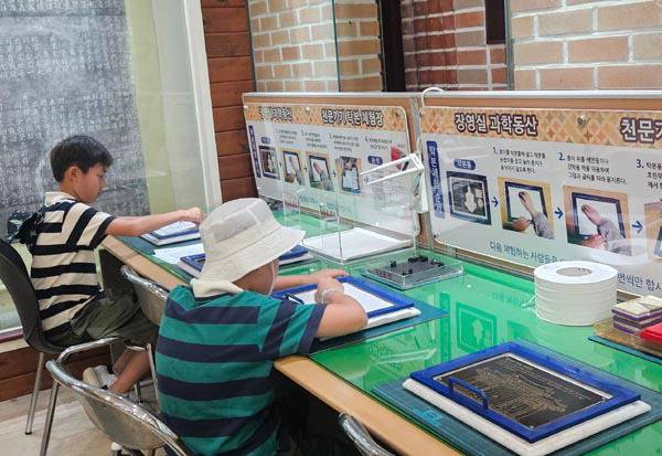 어린이들이 부산 동래구 장영실 과학동산에서 천문기기 탁본 체험을 하고 있다.