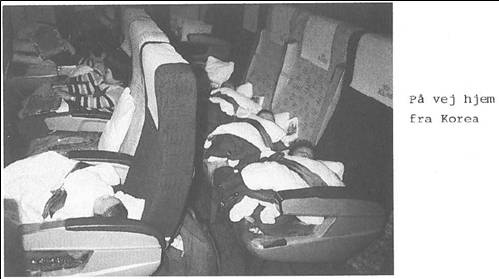 Korean babies sleep aboard an airplane bound for Denmark in 1984. The photo, copied from a Danish adoption agency's report published that year, is accompanied by the explanation on the right that the infants are ″on their way home from Korea.″ [TRUTH AND RECONCILIATION COMMISSION]