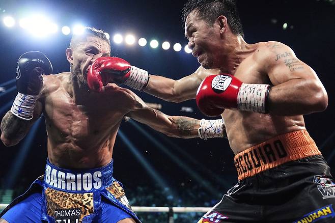 매니 파키아오(오른쪽)가 20일 미국 라스베이거스 MGM 그랜드 가든 아레나에서 열린 WBC 웰터급 세계챔피언전에서 마리오 바리오스의 안면에 라이트 스트레이트를 적중시키고 있다. 파키아오는 이날 자신보다 열여섯 살 어린 챔피언 바리오스를 상대로 녹슬지 않은 경기력을 선보이며 무승부를 기록했다.  AP연합뉴스