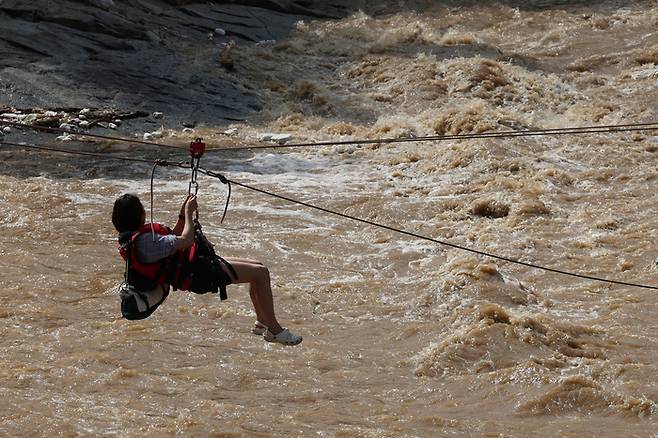 20일 경기 가평군 마일리의 한 캠핑장에 고립된 시민들이 소방 로프를 타고 탈출하고 있다. 2025.7.20 [뉴스1]