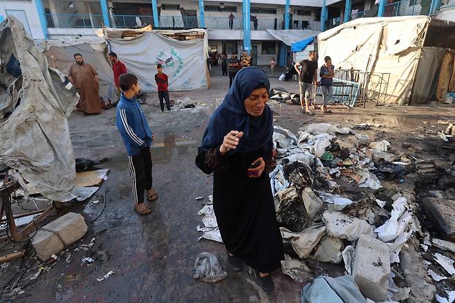 가자지구 중부의 이스라엘 공습 현장 둘러보는 팔레스타인 피란민들 [AFP]