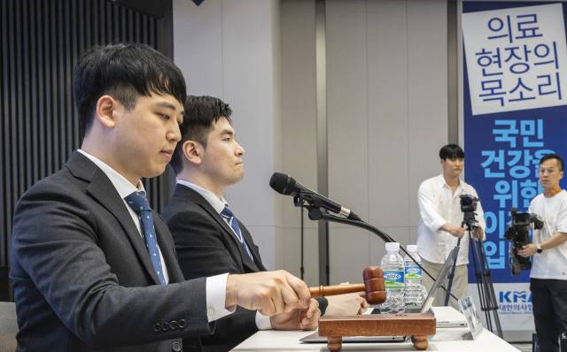 한성존(왼쪽) 대한전공의협의회 비상대책위원장이 19일 서울 용산구 대한의사협회 대강당에서 열린 임시대의원총회 개회를 알리는 의사봉을 두드리고 있다. 오른쪽은 김은식 세브란스병원 전공의 대표. 연합뉴스