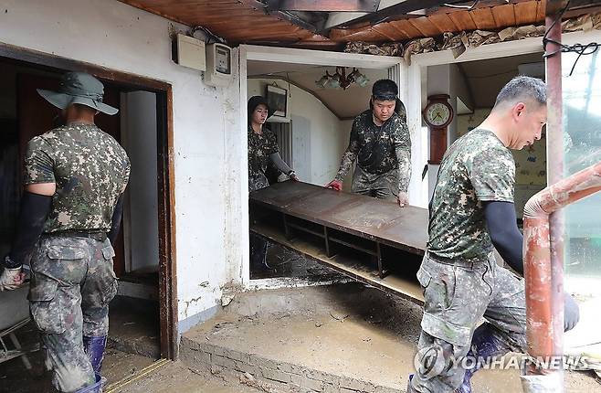 힘 보태는 장병들 (아산=연합뉴스) 김소연 기자 = 20일 집중호우에 침수 피해가 발생한 충남 아산시 염치읍 일원에서 육군 32사단 장병들이 수해 복구를 하고 있다. 2025.7.20 soyun@yna.co.kr