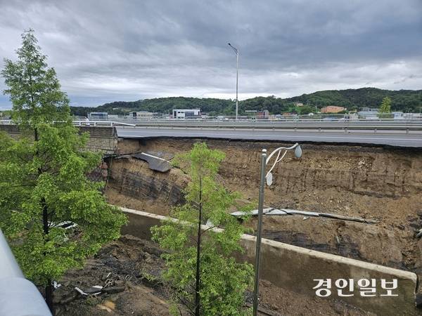 지난 16일 오후 7시께 오산 가장동 서부우회도로의 고가도로 옹벽이 무너지면서 1명이 사망했다. 밤새 내린 비로 복구작업이 중단된 17일 오전, 무너진 옹벽 흙더미 속에 전날 사고의 잔해가 어지럽게 흩어져있다. 2025.7.17 오산/공지영기자 jyg@kyeongin.com