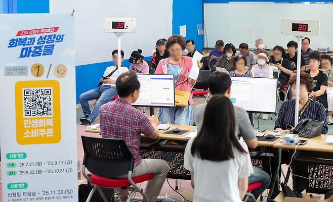▲ 소비 활성화와 소상공인 및 자영업자 매출 확대를 위한 정부의 민생회복 소비쿠폰 1차 신청 첫날인 21일 오전 수원시 팔달구 인계동 행정복지센터에서 시민들이 민생회복 소비쿠폰을 신청하고 있다. 시스템 과부하, 주민센터 혼잡 방지 등을 위해 오는 25일까지 요일제에 따라 출생 연도 끝자리 1·6은 월요일, 2·7은 화요일, 3·8은 수요일, 4·9는 목요일, 5·0은 금요일에 신청할 수 있다. /전광현 기자 maggie@incheonilbo.com
