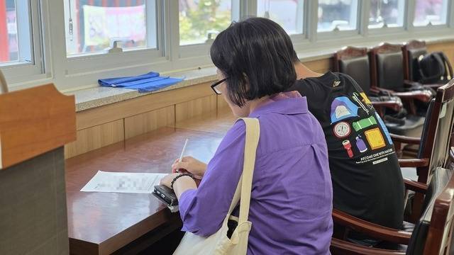 ▲ 민생회복 소비쿠폰 1차 신청 첫 날인 21일 충북 청주시 사창동 행정복지센터에서 시민들이 신청서를 작성하고 있다. /남연우 기자