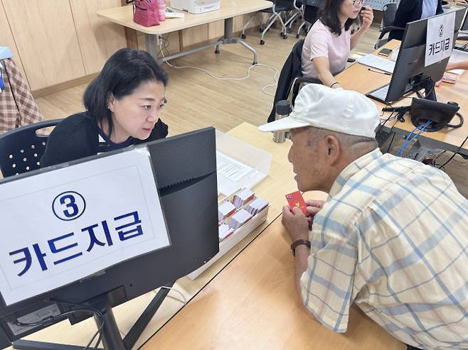 21일 오전 8시30분 서구 치평동 행정복지센터. 센터 앞은 개장 30분 전부터 '민생회복 소비쿠폰'을 받고자 모인 주민들로 북적였다. 사진은 치평동 주민 정모씨(80대)가 민생회복 소비쿠폰 신청 절차를 거치는 모습. /임지섭 기자 ljs@namdonews.com