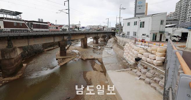 수마가 할퀴고 간 광주 도심이상 기후로 인해 '극한호우'가 일상이 된 현재, 광주 침수 피해 등을 예방하기 위해서는 치수(治水) 인프라를 단기 대책 보다는 '중장기' 대책으로 변환해 나가야 한다는 지적이 나온다. 사진은 21일 광주광역시 북구 신안교(서방천) 인근 옹벽이 최근 내린 폭우로 무너져 관계자들이 임시 복구 조치를 실시한 모습. /임문철 기자 35mm@namdonews.com