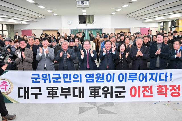 김진열 대구 군위군수와 최규종 군의회 의장, 군의원이 도심 군부대 이전이 결정되자 박수로 환영하고 있다. 군위군 제공