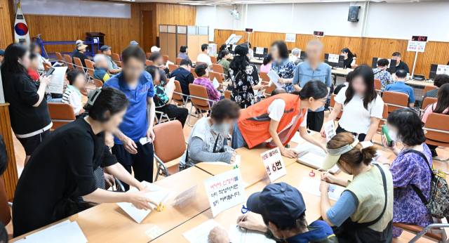 민생회복 소비쿠폰 지급 첫날인 21일 창원시 성산구 사파동 행정복지센터에서 주민들이 신청절차를 밟고 있다./전강용 기자/