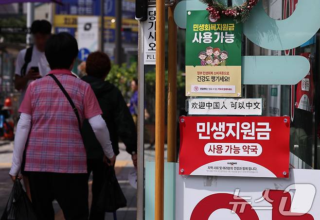 민생회복 소비쿠폰 1차 신청 첫 날인 21일 서울의 한 약국에 쿠폰 사용 관련 포스터가 붙어 있다. 2025.7.21/뉴스1 ⓒ News1 구윤성 기자