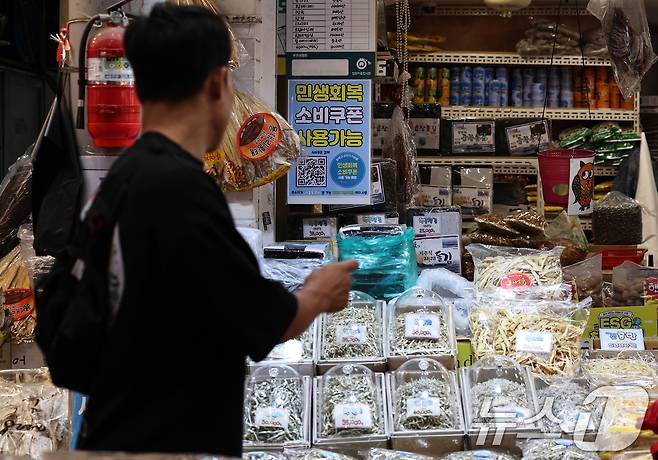 민생회복 소비쿠폰 1차 신청 첫 날인 21일 서울의 한 전통시장에 쿠폰 사용 관련 포스터가 붙어 있다. 2025.7.21/뉴스1 ⓒ News1 구윤성 기자