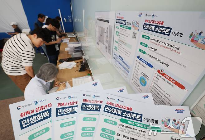 '민생회복 소비쿠폰'의 1차 신청 첫날인 21일 오전 경기 수원시 팔달구 인계동행정복지센터에서 시민들이 신청서를 작성하고 있다. 2025.7.21/뉴스1 ⓒ News1 김영운 기자