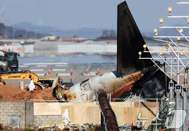 전남 무안국제공항 참사 현장에서 국과수 관계자들이 로컬라이저(방위각시설) 둔덕에 파묻힌 엔진을 살펴보고 있다. 2025.1.3/뉴스1 ⓒ News1 오대일 기자