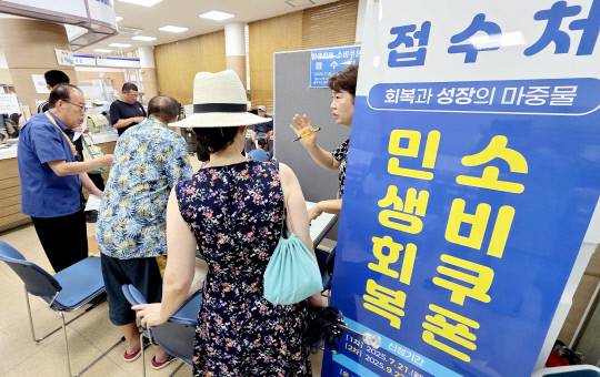 대전 유성구 온천2동행정복지센터 직원들이 시민들에게 민생회복지원금 신청을 안내하고 있다. 김영태 기자