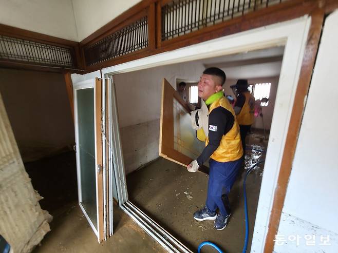 기록적인 폭우로 침수 피해를 입은 광주 북구 신안교 인근 주택에서 광주 지역 사회봉사단체 회원들이 무더위 속에 복구 작업을 벌이고 있다. 박영철 기자 skyblue@donga.com