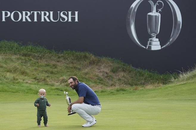 디오픈에서 올 시즌 두 번째이자, 통산 네 번째 메이저 우승을 거둔 스코티 셰플러(오른쪽)가 우승 트로피를 한 손에 든 채 아들 베넷을 바라보고  있다. 포트러시=AP 뉴시스