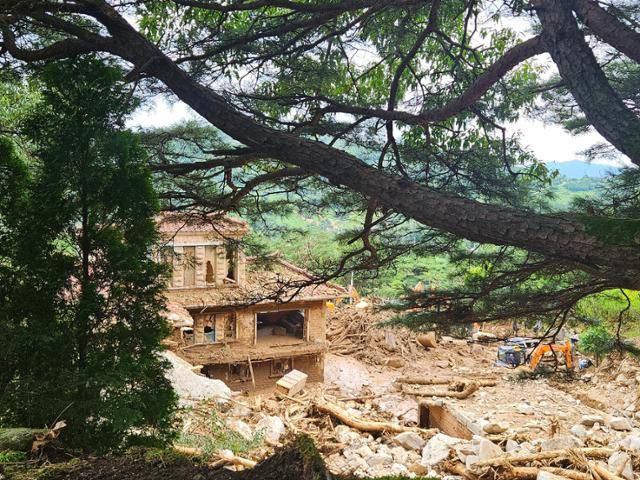 21일 경남 산청군 방목리의 한 주택이 산사태로 쏟아져 내린 흙더미 속에 잠겨 있다. 산청=최현빈 기자