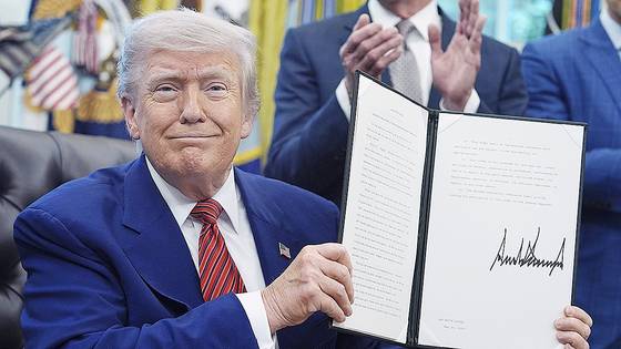 도널드 트럼프 미국 대통령이 지난 5월 백악관에서 자신이 서명한 행정명령 서류를 들어보이고 있다. AP=연합뉴스