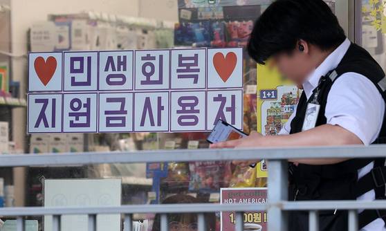 행정안전부가 민생회복 소비쿠폰 신청을 앞두고 국민비서를 통해 지급금액과 신청방법 등 정보를 사전 안내하는 서비스를 지난 14일부터 시작했다. 알림 서비스는 오는 19일부터 사용 종료 시까지 신청자에게 지급금액, 신청기간과 방법, 사용기한, 이의신청 결과 등을 맞춤형으로 안내한다. 다만 알림을 받았다고 자동 신청되는 것은 아니며, 카드사 앱이나 누리집, 주민센터 등을 통해 별도 신청이 필요하다. 사진은 지난 13일 서울 시내 한 편의점에 게시된 민생회복 지원금 사용 관련 안내문. 뉴스1