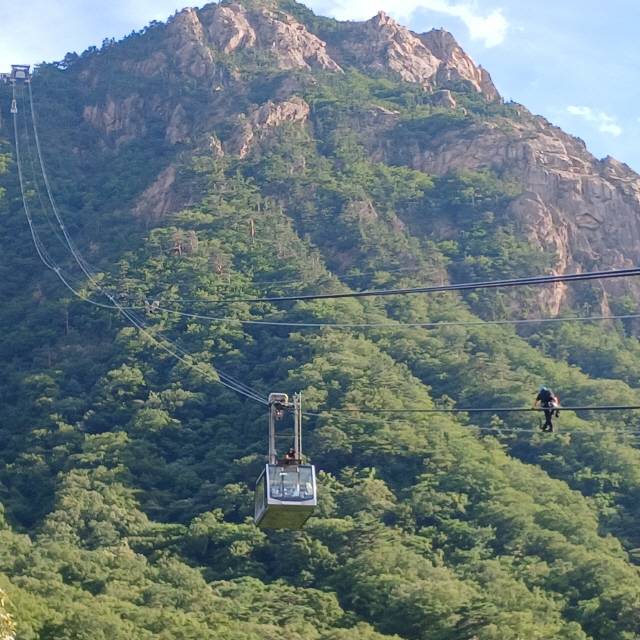 ▲ 20일 오후 3시 50분쯤 갑자기 운행이 중단돼 공중에 매달린 설악산 권금성케이블카를 고치기 위해 직원들이 로프를 타고 이동하고 있다.  독자 제공