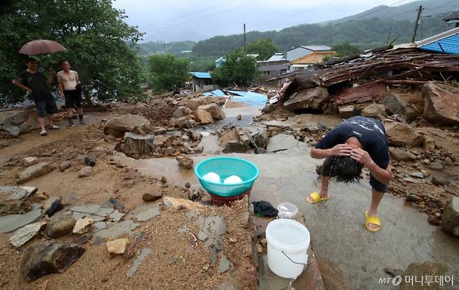 (산청=뉴스1) 윤일지 기자 = 21일 경남 산청군 산청읍 병정마을에서 주민과 자원봉사자가 수해 복구작업 중 흐르는 물로 머리를 씻고 있다.  2025.7.21/뉴스1  Copyright (C) 뉴스1. All rights reserved. 무단 전재 및 재배포,  AI학습 이용 금지. /사진=(산청=뉴스1) 윤일지 기자