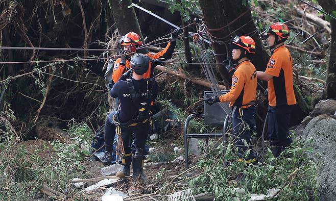 소방대원들이 지난 20일 산사태가 발생한 경기 가평군 마일리 내 한 펜션에서 고립자 구조작업을 펼치고 있다. 뉴시스