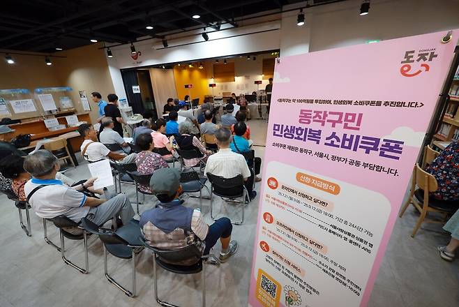 민생회복 소비쿠폰 신청이 시작된 21일 서울 동작구 대방동주민센터 작은도서관에서 시민들이 소비쿠폰 신청 순서를 기다리고 있다. ⓒ연합뉴스