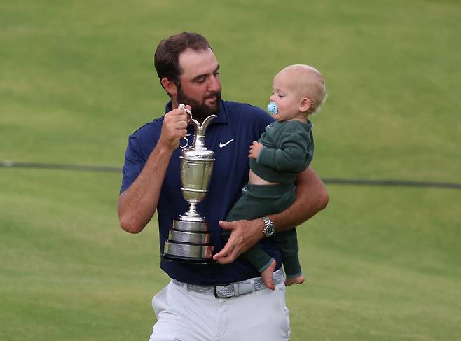 스코티 셰플러가 21일 영국 북아일랜드 포트러시의 로열 포트러시GC에서 열린 제153회 디 오픈을 우승한 뒤 순은제 트로피 클라레 저그를 들고 아들 베넷과 역사적 순간을 즐기고 있다. 포트러시｜로이터 연합뉴스