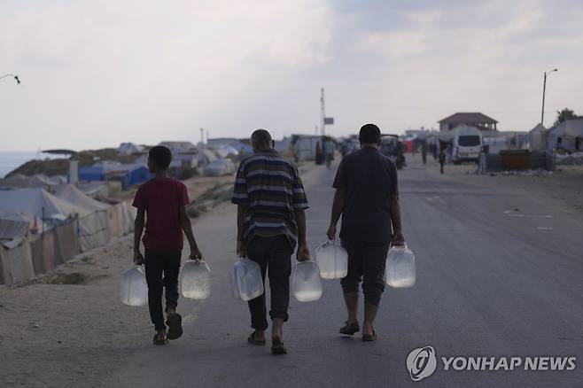 물병 들고 가는 데이르알발라의 팔레스타인 주민 [AP 연합뉴스 자료사진. 재판매 및 DB 금지]