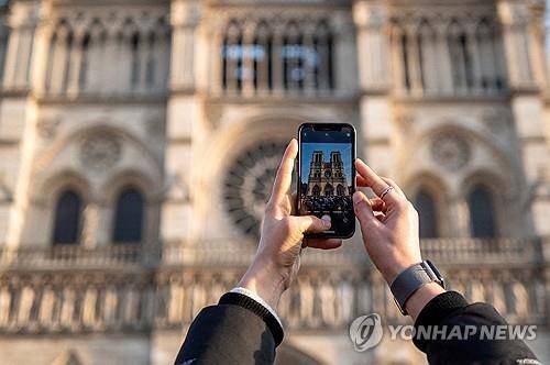 노트르담 대성당을 스마트폰으로 찍고 있는 관광객  [로이터=연합뉴스 자료사진. 재판매 및 DB 금지]
