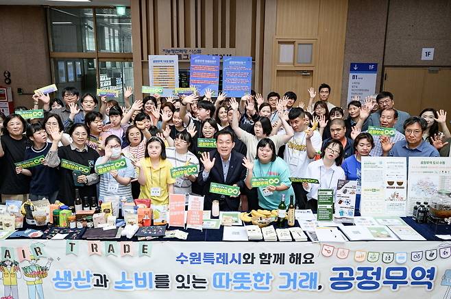 ▲ 지난해 5월 수원시청에서 공정무역 캠페인이 열려 이재준 수원시장과 참석자들이 기념촬영을 하고 있다./사진제공=수원시